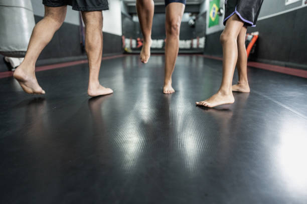 Sumo wrestler, stretching and team with Japanese people in dojo ring for shiko ritual, training or martial arts fight. Tournament, challenge and battle with men for festival, warm up and culture