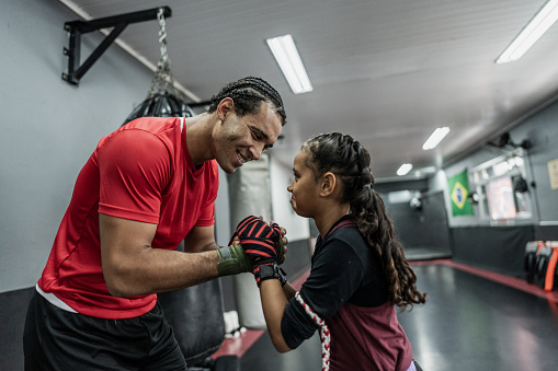 Boxe instructor and child girl greeting at gym