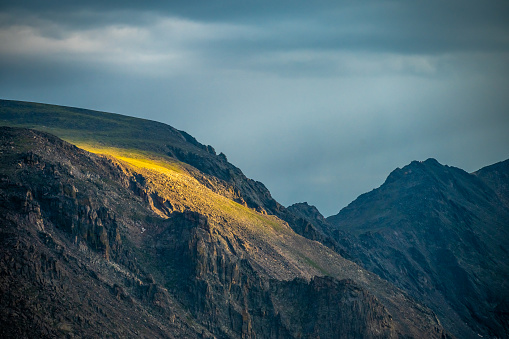 Sunlight Spills Over a Cliff In The Tundra Of Rocky Mountain National Park