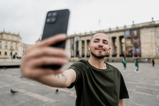 Traveler young man taking a selfie at square in Bogota, Colombia