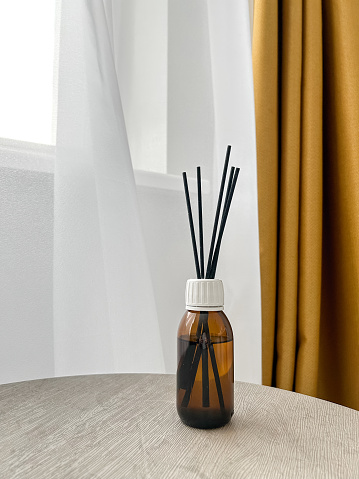 Aroma diffuser on the table, near a gray wall, space for text. Interior decor, aromatic air freshener, incense