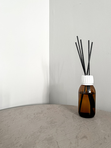 Aroma diffuser on the table, near a gray wall, space for text. Interior decor, aromatic air freshener, incense
