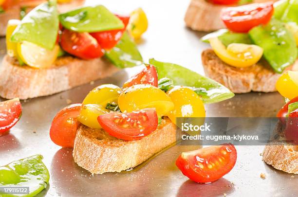 Tomate Cereja E Neve Ervilhas Crostini No Tabuleiro De Cozinhados - Fotografias de stock e mais imagens de Azeite