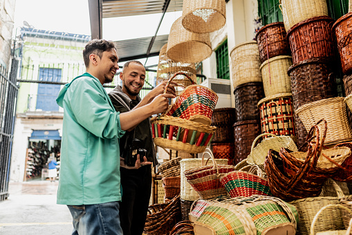 Traveler gay couple looking a basket at street market