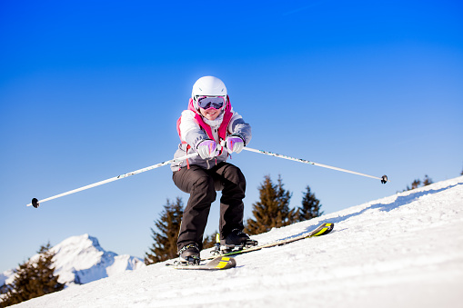 girl skiing and posing on the snow. clear blue sky background