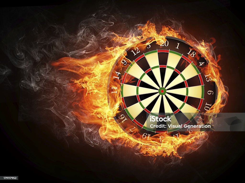 A vintage darts board smothered in flames Darts Board in Fire Isolated on Black Background. Darts Stock Photo