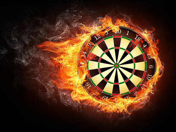 A vintage darts board smothered in flames Darts Board in Fire Isolated on Black Background. dartboard stock pictures, royalty-free photos & images
