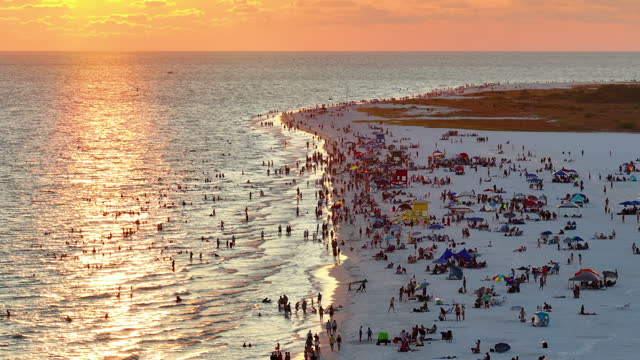 Aerial view of Siesta Key beach in Sarasota, USA. Many people enjoing vacation time swimming in gulf water and relaxing on warm Florida sun at sunset