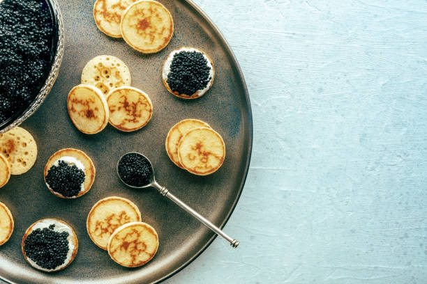istock Blinis with black caviar and cream cheese, overhead flat lay shot 1791199123