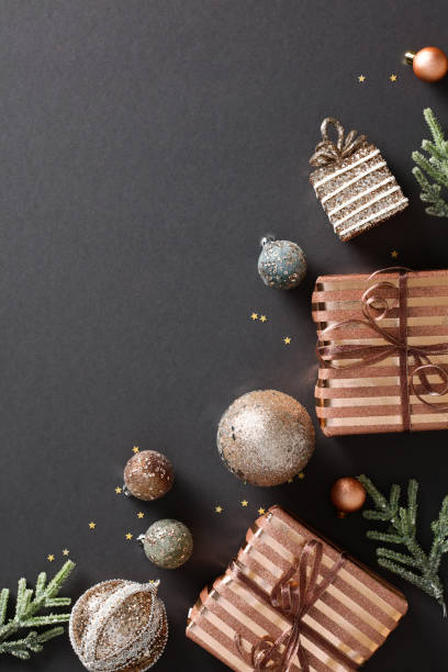istock Chic Christmas composition with elegant black background adorned with festive elements - bronze gift box, glittering baubles, and confetti. Modern holiday poster or postcard template 1791200334