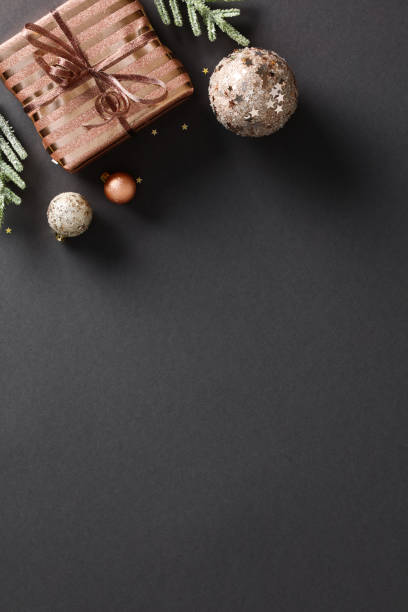 istock Christmas vertical banner with elegant design, featuring festive decorations, gift boxes, and bronze ornaments. Dark background with confetti and a touch of glamour. Perfect for holiday cards, posters 1791203907