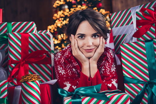 Closeup photo of young model bob brown hair woman posing hands cheeks satisfied dream between wrapped packages merry christmas vibe.