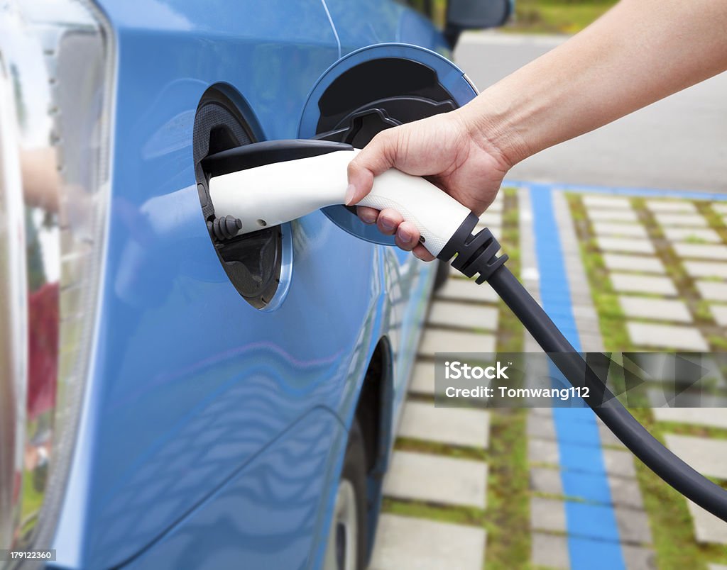 Main tenant prise de recharge pour voiture électrique - Photo de Voiture électrique libre de droits