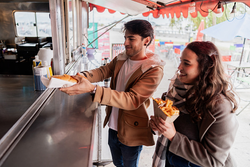 Mid adult couple taking food on a food truck