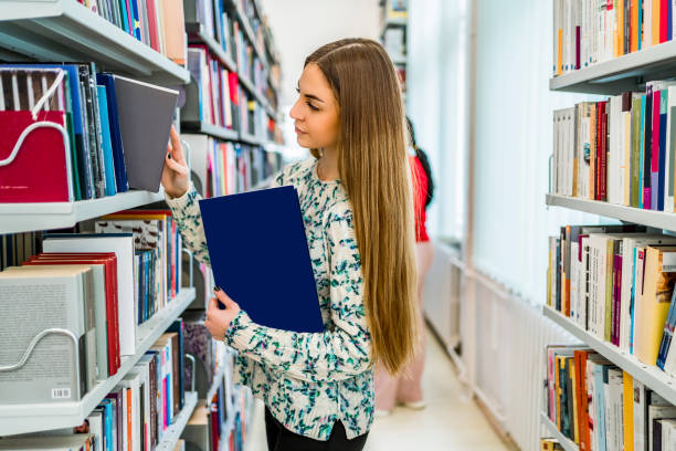 istock Young female student choosing a book in the library 1791241397