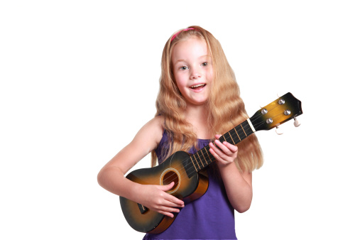 little girl in purple dress playing the ukulele