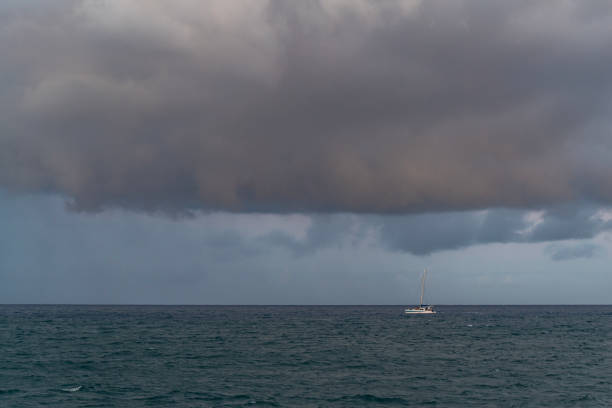 istock Ocean scene with rain clouds above and a boat. 1791241981