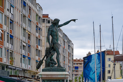 Bronze sculpture named Génie de la Navigation by Louis-Joseph Daumas erected 1847 at seashore of French City of Toulon on a cloudy late spring day. Photo taken June 9th, 2023, Toulon, France.