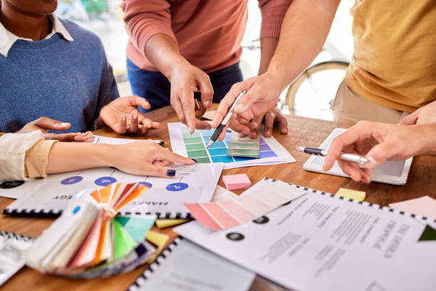 istock Hands, documents and strategy with a designer team working on a creative project together in the office. Meeting, data and marketing with a group of design people at work in the boardroom closeup 1791262755