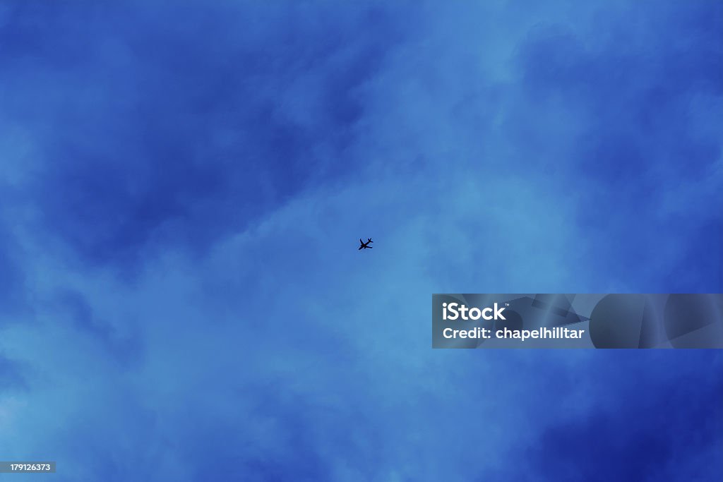 Aeroplano volare nel buio nuvole - Foto stock royalty-free di A mezz'aria