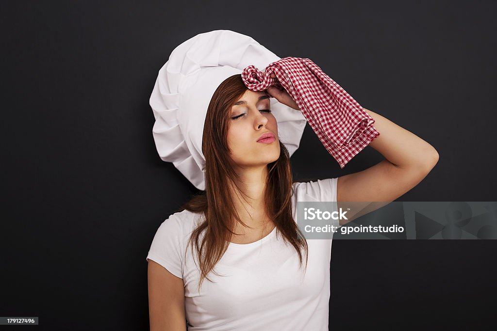 Very tired female chef wiping face from sweat Chef Stock Photo