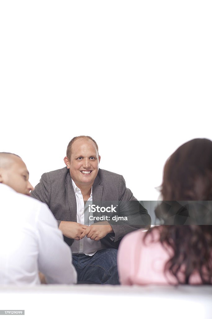 Uomo d'affari sorridenti davanti a due colleghi - Foto stock royalty-free di Abbigliamento formale