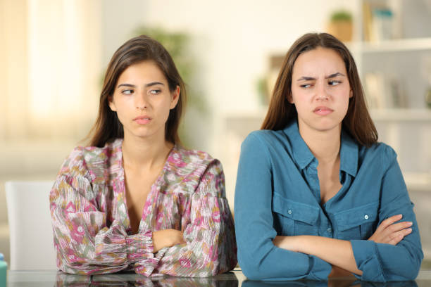 Angry friends ignoring each other at home