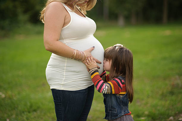istock Daughter Kissing Mommy's Belly 179129878