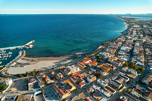 Torre de la Horadada beach, view  from above. Drone point of view seaside and residential houses rooftops at sunny day. Costa Blanca, Alicante, Spain. Travel and holidays