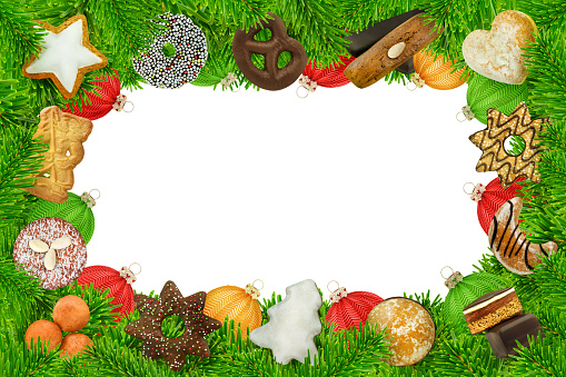 Frame and various Christmas sweets and cookies with fir branches and balls isolated against white background