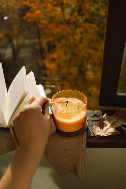 istock Hand with burning match lighting a candle on the windowsill 1791327582