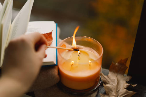 istock Hand with burning match lighting a candle on the windowsill 1791327613