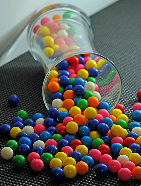 Colored Gumballs Spilling Out of a Jar stock photo