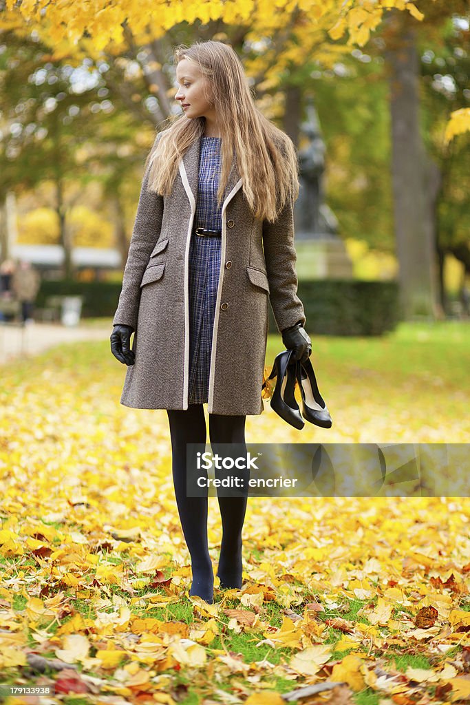 Ragazza in una giornata autunnale, con le sue scarpe in mano - Foto stock royalty-free di Abbigliamento casual