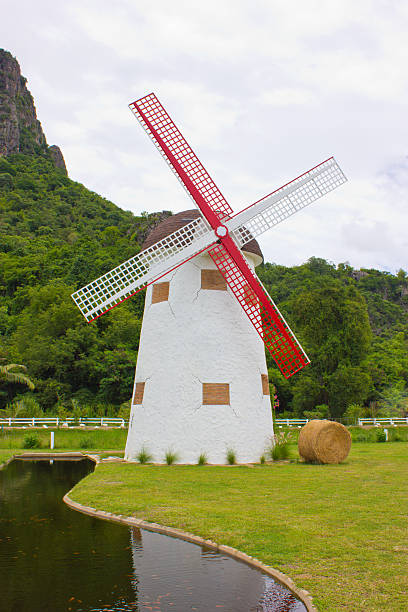 istock Windmill, hay roll, green field and canal. view in farm. 179134743
