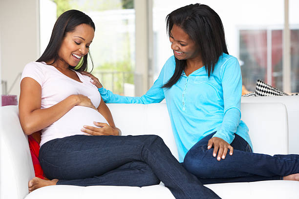 mujer embarazada amigo en casa visitando - baby shower women home interior indoors fotografías e imágenes de stock