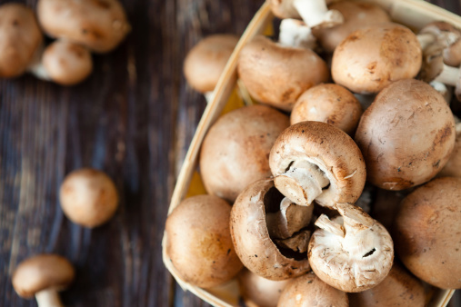 champignons in a basket on dark boards, food