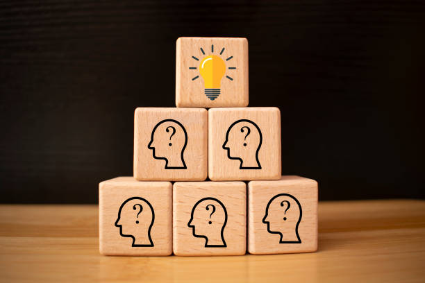 istock team creative idea or innovative idea concept, Brainstorming process, Wooden blocks with question mark head icon stacked in pyramid stair shape and the top one with light bulb. 1791363763