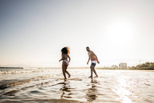 istock Father and daughter having fun while playing in the sea on the beach 1791370983