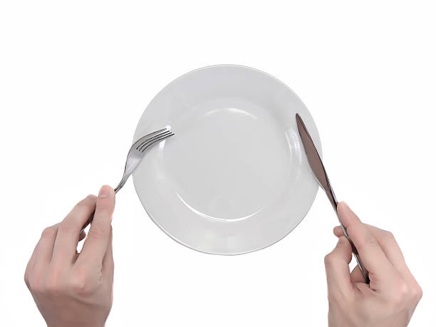 istock Hands hold fork and knife above plate. 179137271