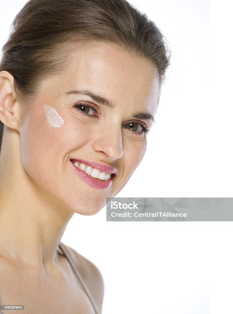 Beauty portrait of happy young woman with creme on cheek Adult Stock Photo