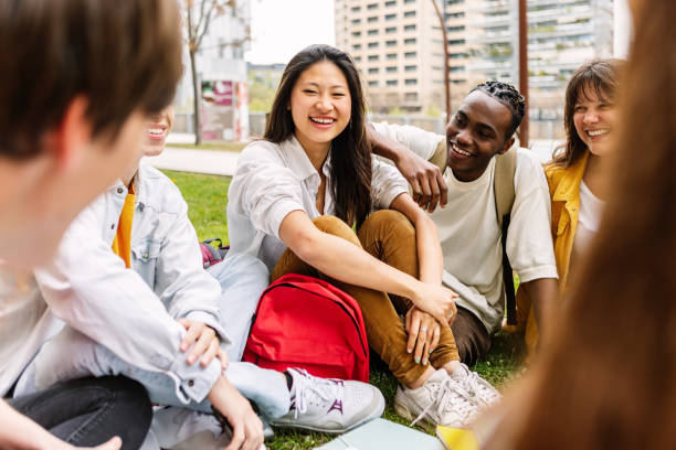 istock Multi-ethnic high school student friends sitting outdoors at campus park. 1791392264