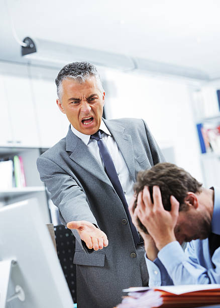 istock Boss reprimanding employee while he hides behind his hands 179139853