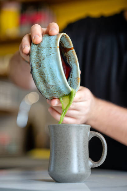 Barista preparing green Matcha latte in his barista shop