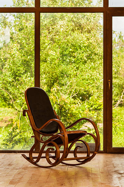 istock Rocking chair  near a large window 179140833