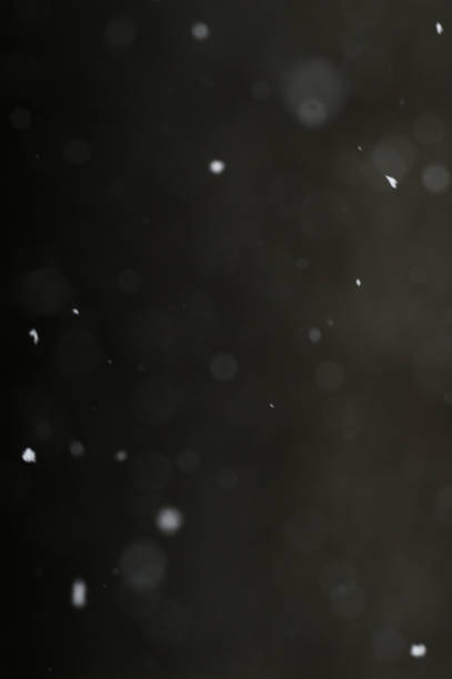 istock Bokeh of white snow on a black background. Snowfall - design element. 1791423743