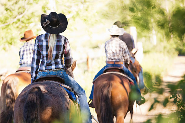 Group of ranchers riding horses together outdoors at ranch Group of ranchers riding horses together outdoors at ranch corral photos stock pictures, royalty-free photos & images