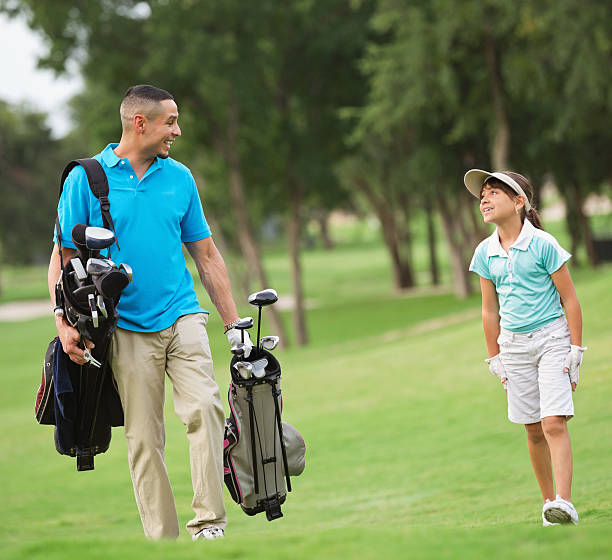 istock Father carrying clubs for daughter while playing golf together 179143302