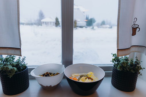 View of ingredients for the German Stollen on the windowsill with view of snowing weather outside