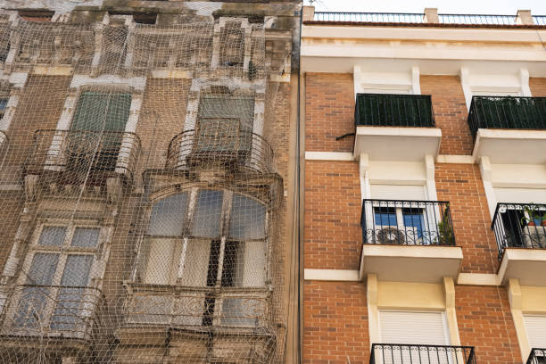 istock An old house is being restored, the whole house will be covered with netting so that nothing falls on people during the restoration 1791450643